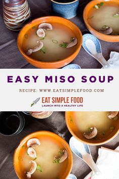 four bowls filled with soup on top of a table next to plates and spoons