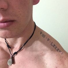 a shirtless man wearing a necklace with words on it