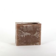 a square candle holder sitting on top of a white surface