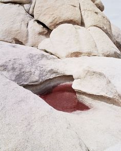 a red pool in the middle of some rocks