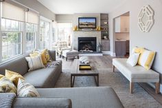 a living room filled with furniture and a fire place in the middle of a room