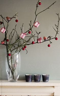 a vase filled with branches and small cups