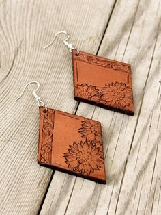 two square shaped wooden earrings with flower designs on the front and back of each ear