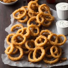 some onion rings and dips on a table