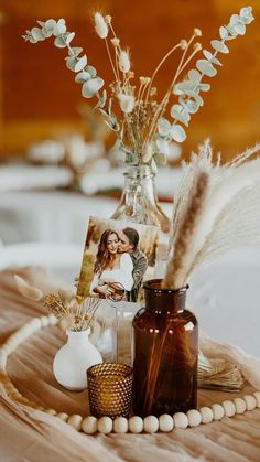 a table topped with vases filled with flowers and pictures