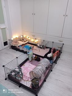 two cages with candles on the floor in front of them and one cage filled with cats