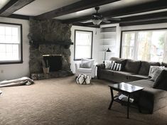 a living room filled with furniture and a fire place in the middle of it's walls