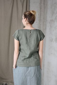 * 100% soft linen * Short sleeve * 2 buttons at the back * Handmade in Slovakia * The model is 176 cm tall, wearing size S, color Olive (this color is no longer available) Measurements: Size XS - cloth (laid on the floor): Bust: 42 cm Length (from the neckline to the hem measured from the back): 56 cm -------------------------- Size S - cloth (laid on the floor): Bust: 44 cm Length (from the neckline to the hem measured from the back): 58 cm --------------------------- Size M - cloth (laid on th Summer Tops In Flax Color With Buttons, Flax Cotton Top With Buttons, Cotton Buttoned Flax Top, Buttoned Flax Cotton Top, Cotton Flax Top With Buttons, Casual Flax Top With Buttons, Casual Buttoned Beige Tops, Flax Colored Tops With Buttons And Relaxed Fit, Green Linen Crew Neck Top