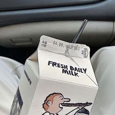 a milk carton sitting in the passenger seat of a car with a sticker on it