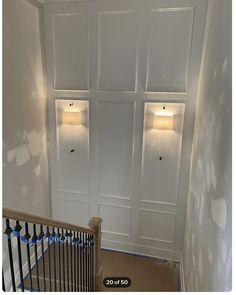 an empty room with white painted walls and wooden handrails in front of the door