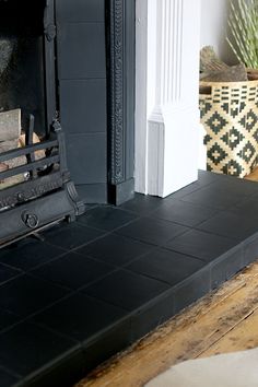 a fireplace with a black tile hearth and white trim