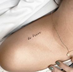 a woman's back with the word be brave tattooed on her left side ribcage