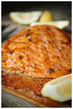 grilled salmon with lemon wedges on a cutting board