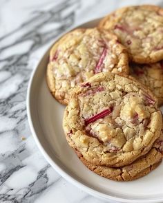 several cookies on a white plate sitting on a marble table