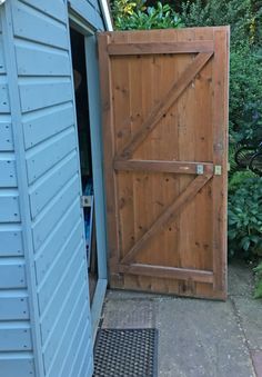 a blue shed with an open wooden door