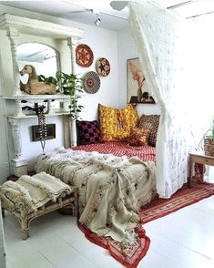 a bedroom with white walls and lots of pillows