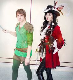 two people dressed up in costumes standing next to each other with one holding a knife