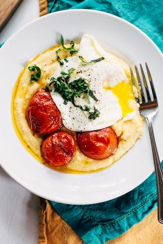 a white plate topped with mashed potatoes and tomatoes