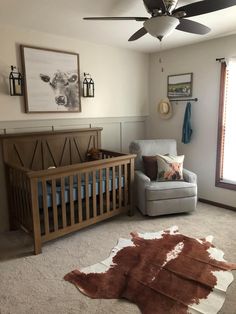 a baby's room with a chair, crib and rug