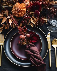 a place setting with flowers and gold cutlery