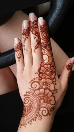 a woman's hand with henna tattoos on it