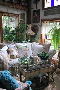 a living room filled with lots of furniture and plants on top of it's tables