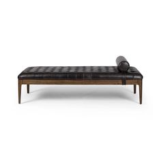 a black leather bench sitting on top of a white floor next to a wooden frame