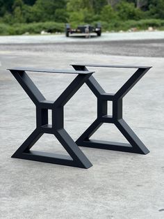 two black tables sitting on top of cement ground