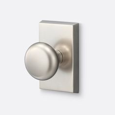 an image of a door knob on a white wall with a silver ball in the middle