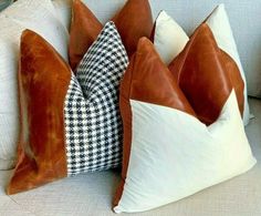 two brown and white pillows sitting on top of a couch