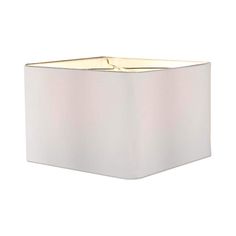 a square light fixture with a white shade on the top and gold trimmings