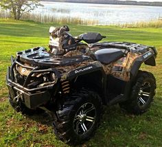 an atv is parked in the grass near some water