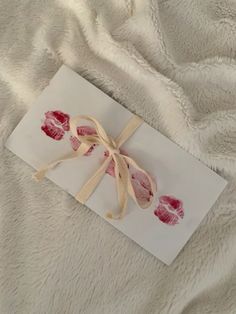 a piece of white paper with red imprints on it sitting on a bed sheet