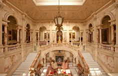 an ornately decorated lobby with chandelier and seating area on the second floor