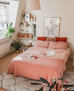 a bed sitting in a bedroom next to a window filled with potted plants and books