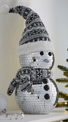 a disco ball snowman sitting on top of a shelf