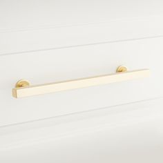 a gold handle on a white cabinet door