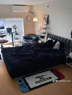 a bed sitting in the middle of a living room next to a desk and chair