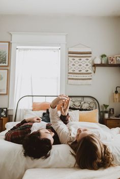 two people laying on top of a bed