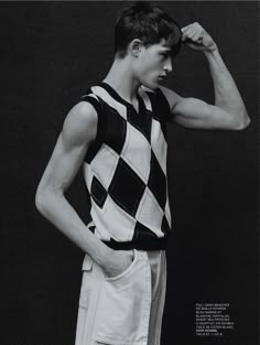 a young man is posing for a photo in black and white, with his hands behind his head