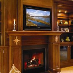 a living room with a fire place and television on the wall above it's fireplace