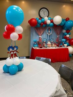 a table with balloons, cake and decorations on it