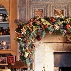 a fireplace decorated for christmas with pine cones and berries