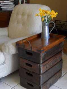 a wooden crate with flowers in it sitting on the floor next to a white chair