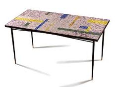 a table made out of mosaic tiles and metal legs