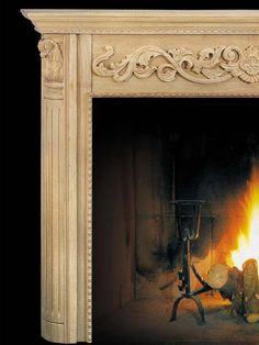 a fireplace with a fire burning in it's mantle and an ornate design on the mantel