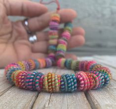 a person is holding some colorful bracelets