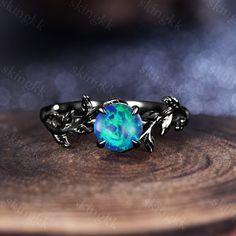 a ring with an opal stone in the center on top of a wooden table