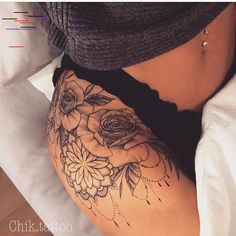 a woman's stomach with tattoos on it and flowers in the middle of her belly