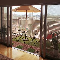 a patio with chairs and an umbrella overlooking the city from it's back deck